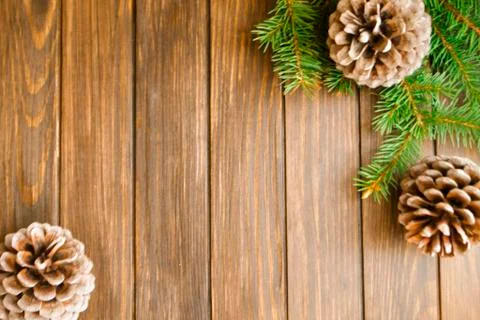 Fir branches and pine cones on rustic wooden board. Christmas background with Stock Photos