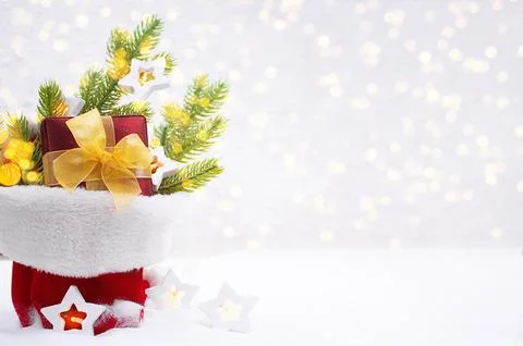 Fir branches, gift box with bow and star bulbs with defocused lights in bag Stock Photos