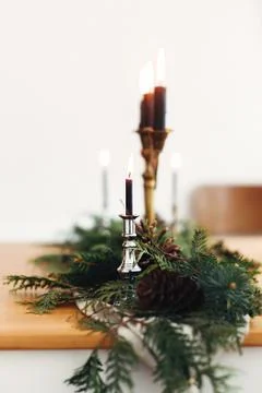 Fir branches with pine cones and vintage candlestick with burning black candl Stock Photos