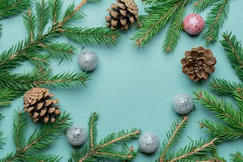 Fir, spruce branches, pine cones and Christmas tree toys on green background  Stock Photos