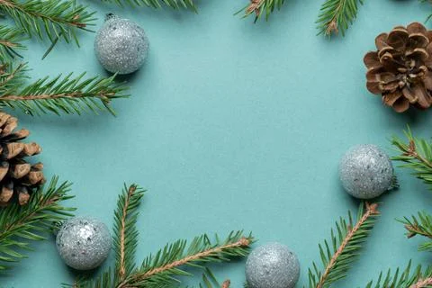 Fir, spruce branches, pine cones and Christmas tree toys on green background  Stock Photos