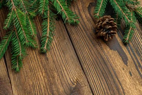 Fir, spruce branches, pine cones on brown wooden background with copy space Stock Photos