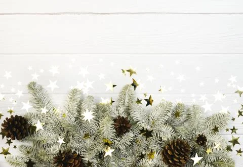 Fir tree border, cones and stars confetti on white background. Christmas holiday Stock Photos