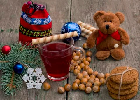 Fir-tree branch, tea, bear, baking, bag and nuts, on a wooden table Stock Photos