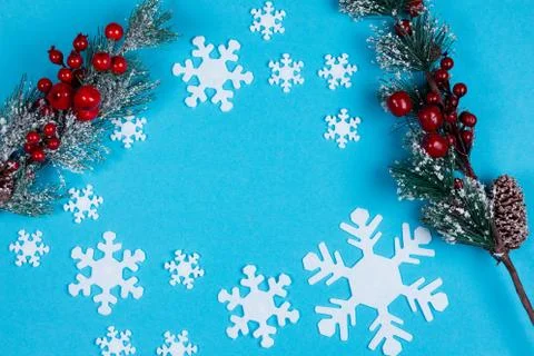 Fir tree branches and snowflakes on the blue background. Stock Photos