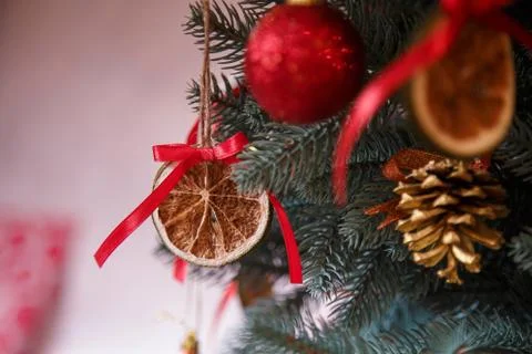Fir-tree branches with red bulbs and cones, decorations hanging on them. Stock Photos