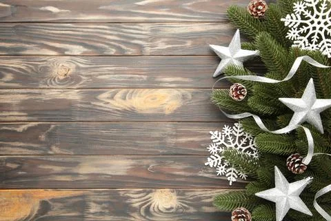 Fir tree branches with silver christmas decoration on a brown background Stock Photos