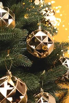 Fir tree with New Year decorations. Shiny gold colored Christmas ornaments. Stock Photos
