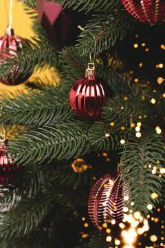 Fir tree with New Year decorations. Metallic red Christmas ornaments. Stock Photos