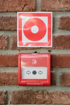 Fire alarm button in emergency system over a wall. Fire alert. Photos