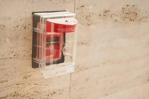 Fire alarm device mounted on wall in public building hallway Fotos de archivo