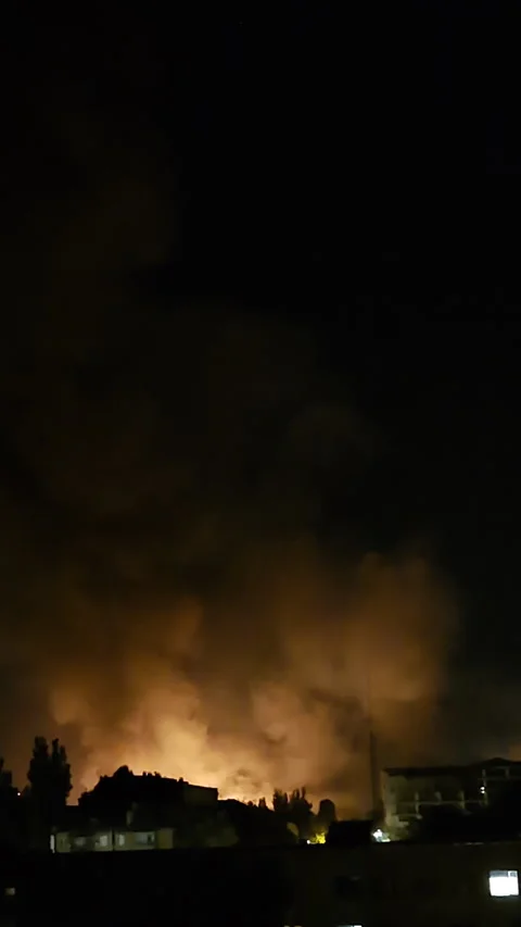Fire and destruction at night with drone and gunfire sounds Stock Footage 312415070