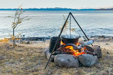 The fire and the pot on a background of lake Foto stock