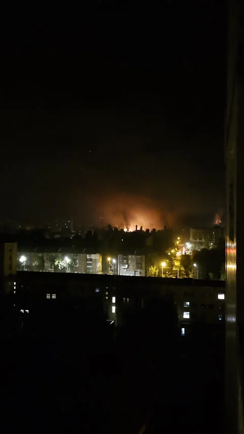 Fire and smoke fill night sky after drone attack and explosions Stockbeeldmateriaal 312415082