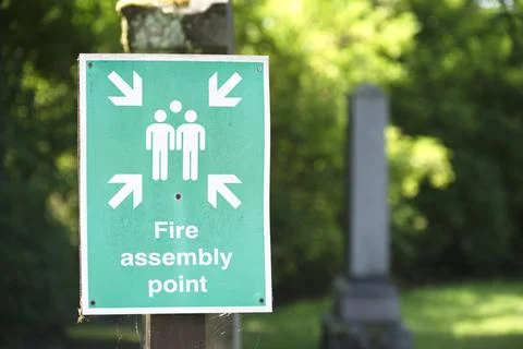 Fire assembly point sign at workplace signpost Stock Photos