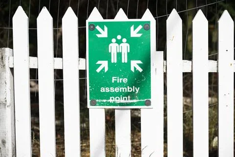 Fire assembly point sign at workplace signpost Stock Photos