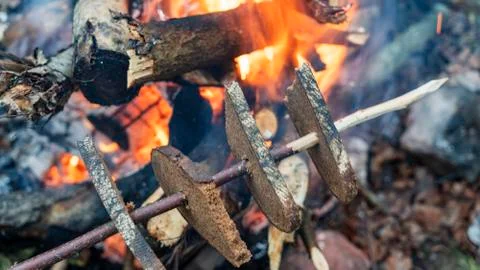 Fire baked bread. Cooking toasts on the grill. A slices of bread is fried on  Stock Photos