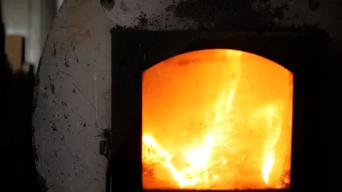 Fire is beautifully lit in a cast iron stove. Bonfire in the furnace Stock Footage 99576869