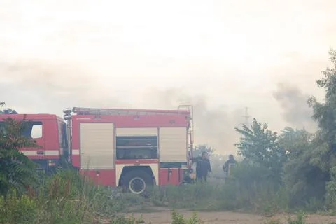 A fire brigade on a fire engine extinguishes a forest fire. Inscriptions on t Stock Photos