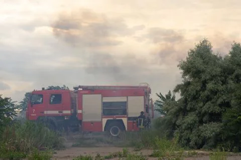 A fire brigade on a fire engine extinguishes a forest fire. Inscriptions on t Stock Photos