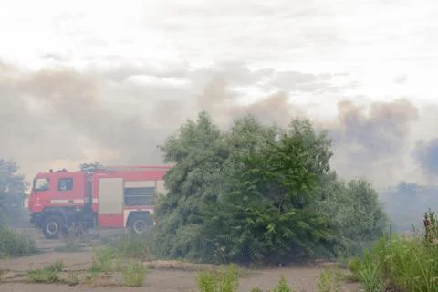 A fire brigade on a fire engine extinguishes a forest fire. Inscriptions on t Stock Photos