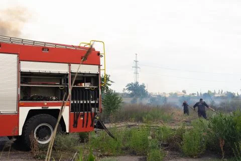 A fire brigade on a fire engine extinguishes a forest fire. Inscriptions on t Stock Photos