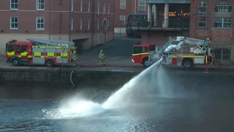 Fire Brigade Fire Engine by river spraying jet Stock-Footage 104351358