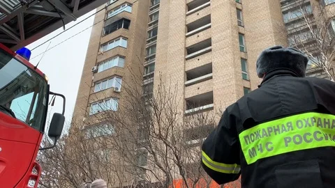 Fire brigade officer stands by a fire engine during a fire Stock Footage 103580037