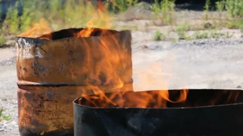 Fire burn in two iron barrels outdoors at sunny day. Video stock 156727016