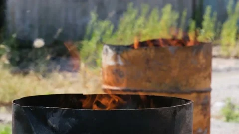 Fire burn in two iron barrels outdoors at sunny day. Video stock 157140326