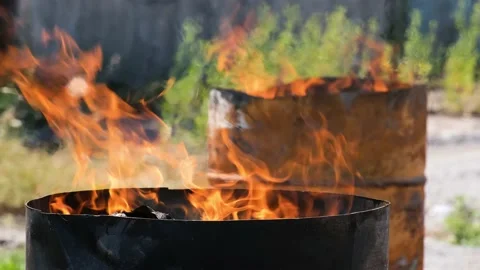 Fire burn in two iron barrels outdoors at sunny day. Stock Footage 158391607