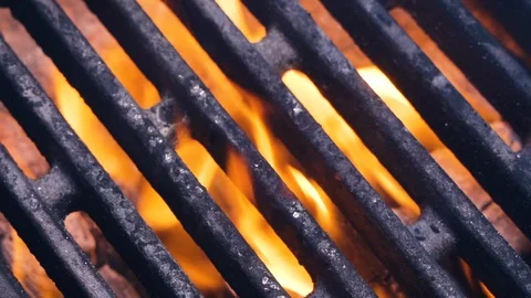 Fire is burning and Tasty meat for a burger falls on a barbecue grill Vidéo 107768552