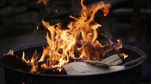 Fire burning in black metal firepit on dark night in patio Stock Footage 74568407