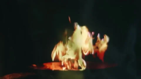Fire burning in bowl is projected onto fabric fluttering in the wind Stock Footage 313154792
