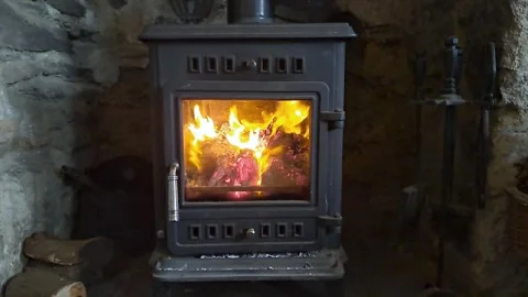 Fire burning brightly inside a stove or log burner showing the whole burner Stock-Footage 265149504