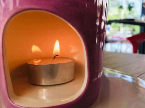Fire burning candle in ceramic pot Foto stock