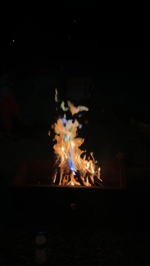A fire is burning in a fire pit at bon fire. The fire is orange and yellow. Stock Footage 288997847