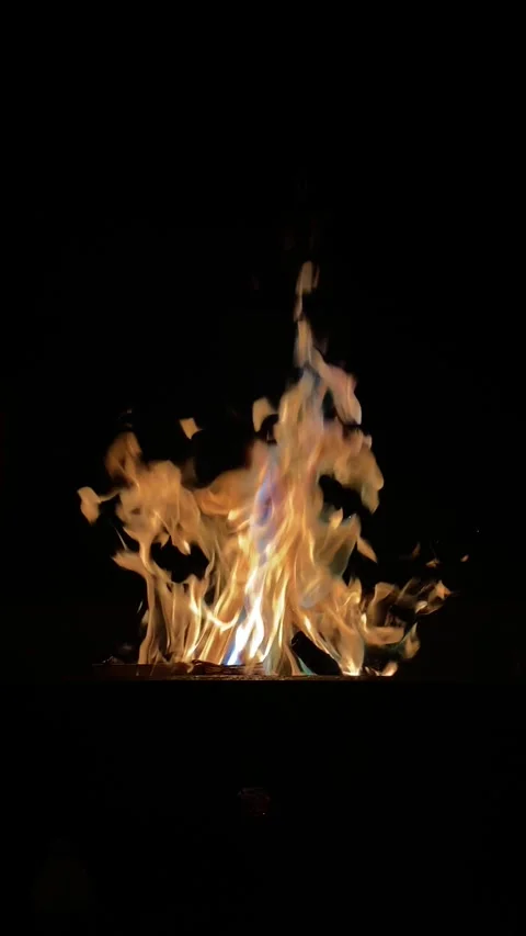 A fire is burning in a fire pit at bon fire. The fire is orange and yellow. Stock Footage 288997887