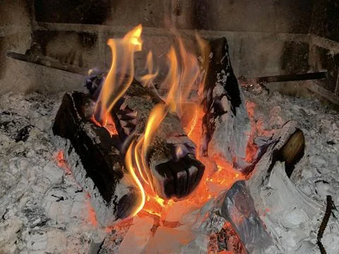A fire is burning in the fireplace, close-up. Burning wood in the fireplace c Stock Photos