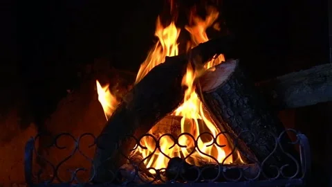 Fire is burning in the fireplace. Hearth. Warmth and home comfort. Flames of a c Stock Footage 152550527