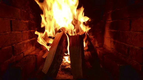 Fire burning in a fireplace with logs and flames dancing brightly during the Stock Footage 344320953