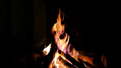 Fire burning in the fireplace. Video of fire flames over dark background Video stock 92077450