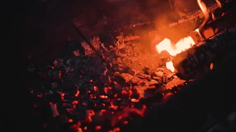 A fire burning in a fireplace, with visible flames and glowing embers. Stock Footage 345874833