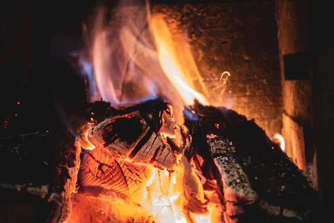 Fire burning glowing in rustic wood burning cast iron stove, log burner for h Stock Photos