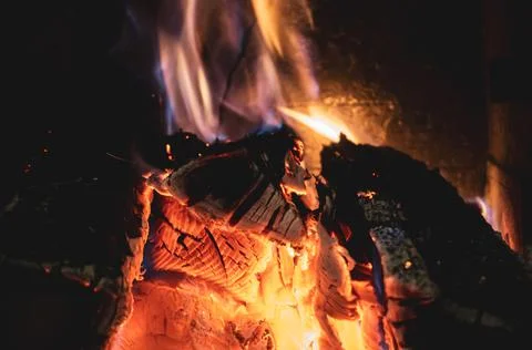 Fire burning glowing in rustic wood burning cast iron stove, log burner for h Stock Photos