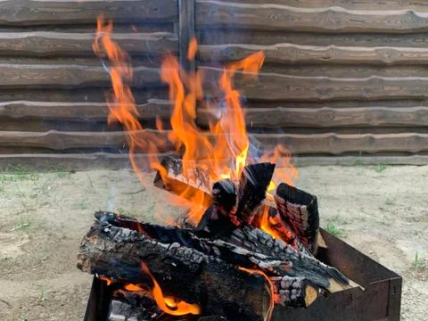 The fire is burning on the grill, close-up. Flame of fire from chopped wood.  Stock Photos