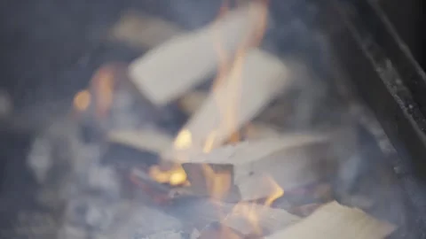 A fire burning in a grill, with the flames reaching up to the sky Stock Footage 301629460