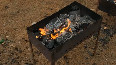 The fire is burning in the grill. Preparation of coals for roasting shish kebab Stock Footage 126955211
