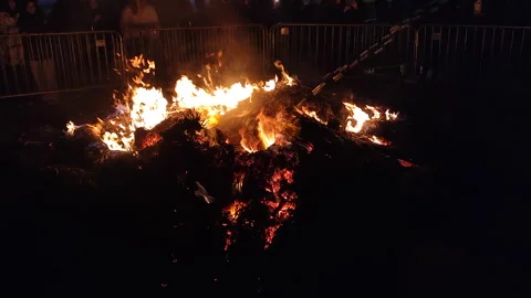 A fire of burning hay is doused with a stream of water at night Stock Footage 305034522