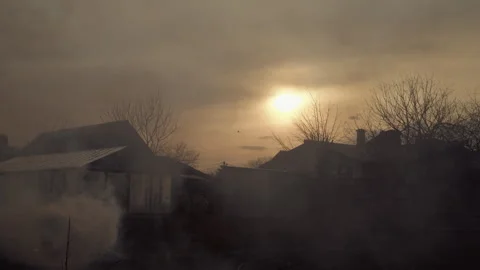 A fire burning near the house, there is heavy smoke, the sun is setting Stock Footage 253225085